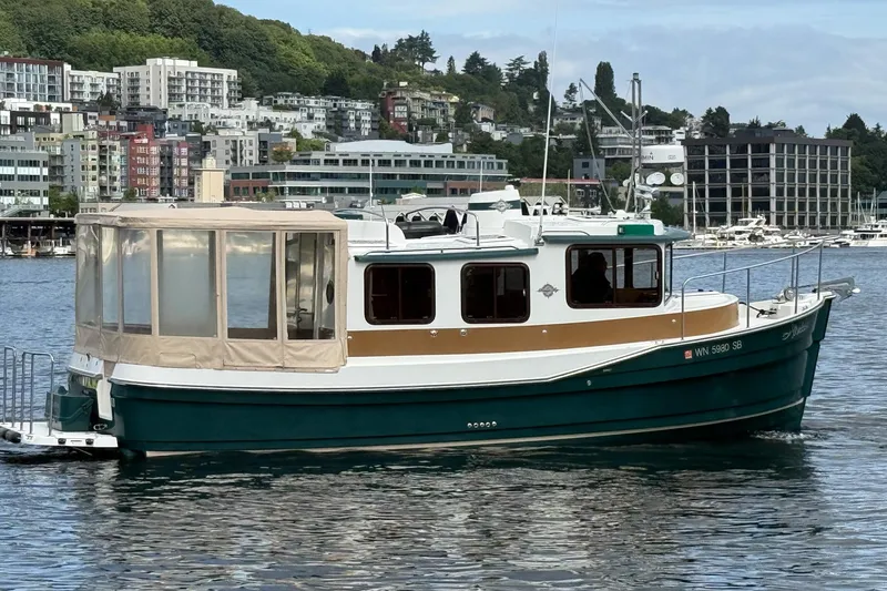 Slide: The Image of 2014 Ranger Tugs R-27 boat docked in a scenic urban marina. - 17