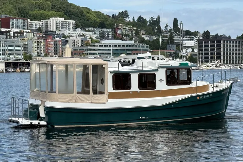 Slide: The Image of 2014 Ranger Tugs R-27 boat on water, urban skyline in background. - 18