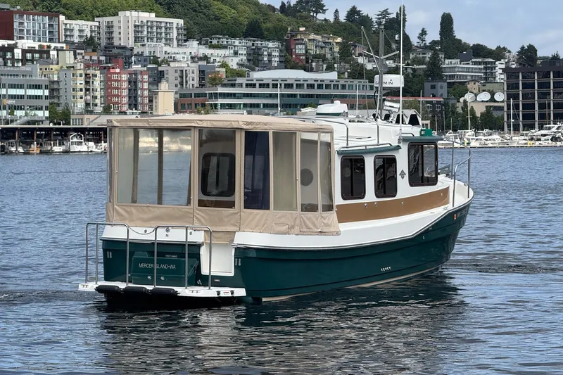 Slide: The Image of 2014 Ranger Tugs R-27 boat cruising on a scenic urban waterfront. - 21