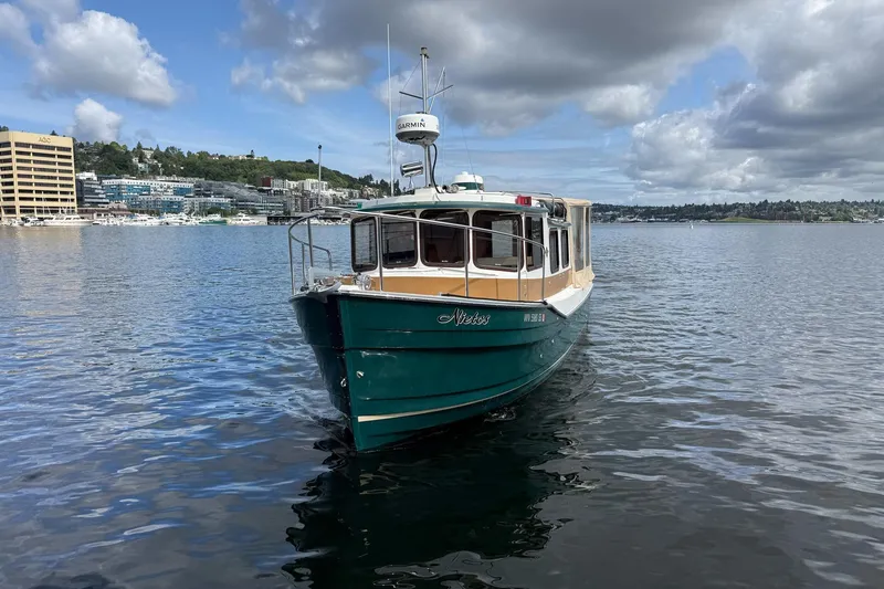 Slide: The Image of 2014 Ranger Tugs R-27 boat on a calm lake under cloudy skies. - 24