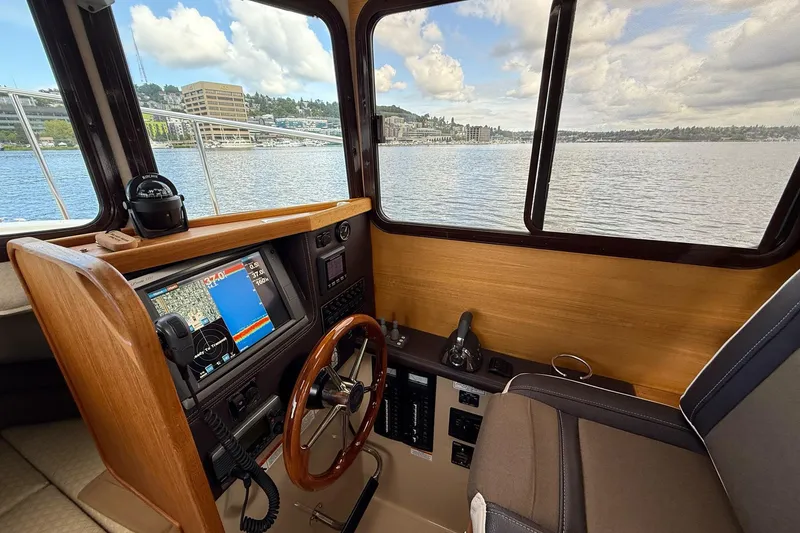 Slide: The Image of Interior view of 2014 Ranger Tugs R-27 helm with navigation equipment and scenic waterway. - 33
