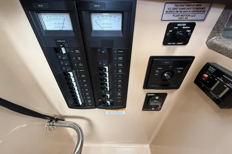 Slide: The Image of Control panel of a 2014 Ranger Tugs R-27 boat, featuring electrical switches and gauges. - 34