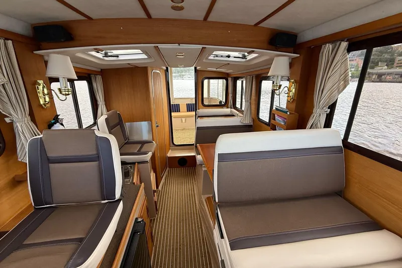 Slide: The Image of Interior of a 2014 Ranger Tugs R-27 boat with seating and windows. - 45