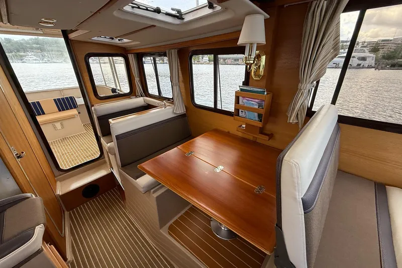 Slide: The Image of Interior of 2014 Ranger Tugs R-27 boat with wooden table and seating area. - 46
