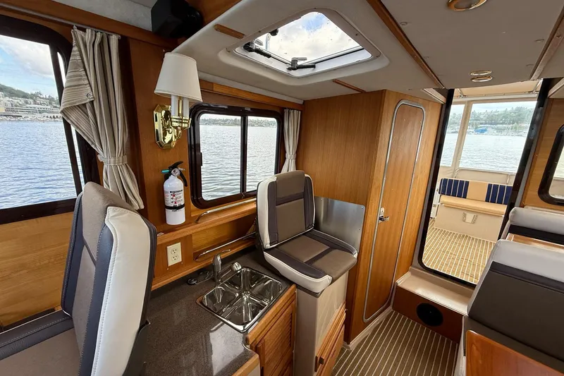 Slide: The Image of Interior of 2014 Ranger Tugs R-27 boat with wood finish and seating area. - 47