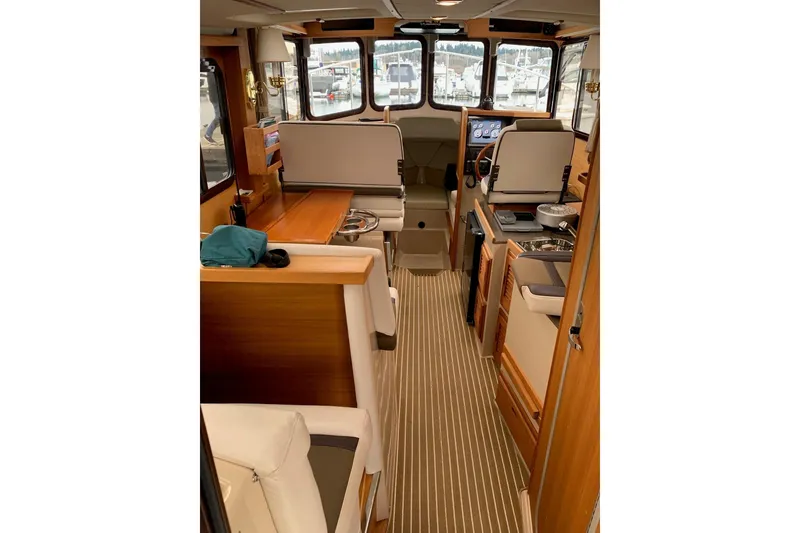 Slide: The Image of 2014 Ranger Tugs R-27 interior with wood accents and seating area. - 5
