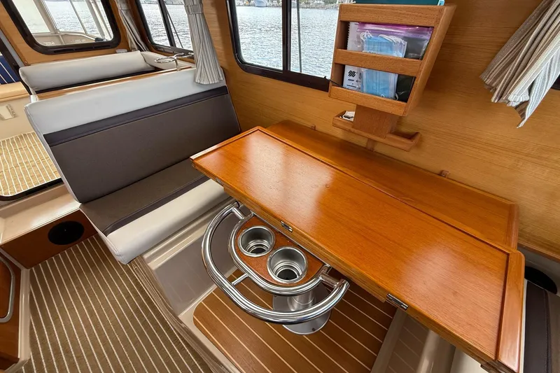 Slide: The Image of Interior of 2014 Ranger Tugs R-27 with wooden table and seating area. - 51