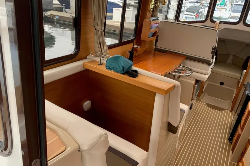 Slide: The Image of Interior of a 2014 Ranger Tugs R-27 boat with wood accents and seating area. - 6