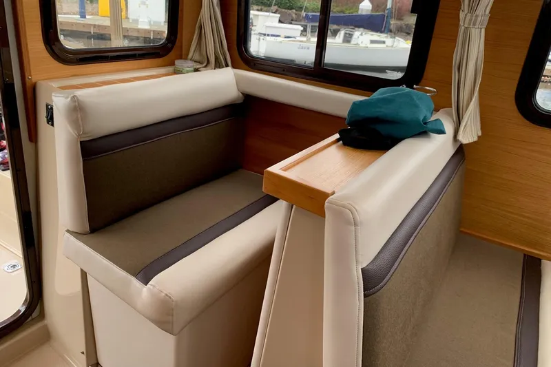 Slide: The Image of Interior seating of 2014 Ranger Tugs R-27 boat with windows and curtains. - 8