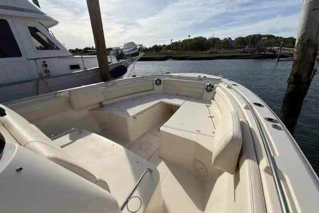 Slide: The Image of 2023 Grady-White Canyon 326 boat with spacious seating, docked by the water. - 12