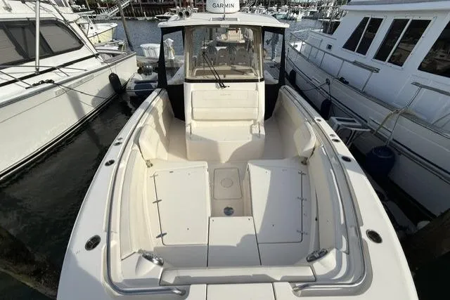 Slide: The Image of 2023 Grady-White Canyon 326 boat docked, showcasing spacious deck and seating area. - 14
