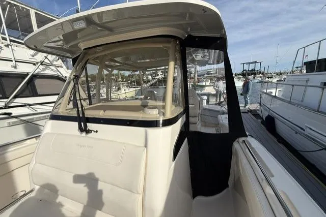 Slide: The Image of 2023 Grady-White Canyon 326 boat docked at a marina, showcasing its helm and seating area. - 15