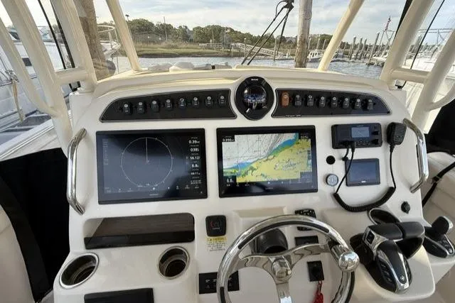 Slide: The Image of Control panel of 2023 Grady-White Canyon 326 boat with navigation screens and steering wheel. - 18