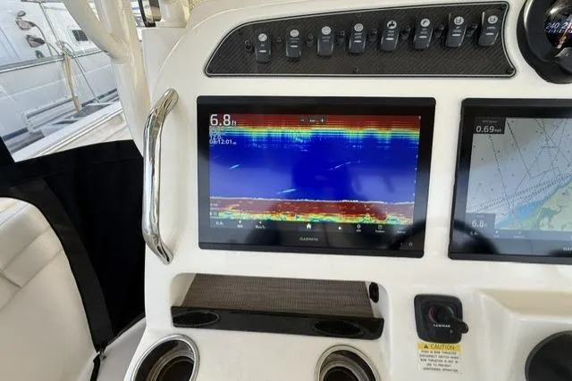 Slide: The Image of 2023 Grady-White Canyon 326 boat dashboard with Garmin navigation display and controls. - 19