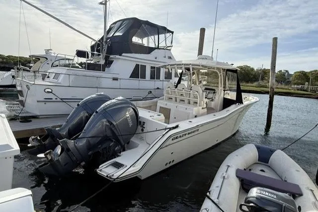 Slide: The Image of 2023 Grady-White Canyon 326 boat docked with twin Yamaha engines. - 2