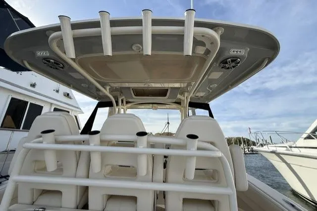 Slide: The Image of 2023 Grady-White Canyon 326 boat interior with rod holders and seating, docked at marina. - 34