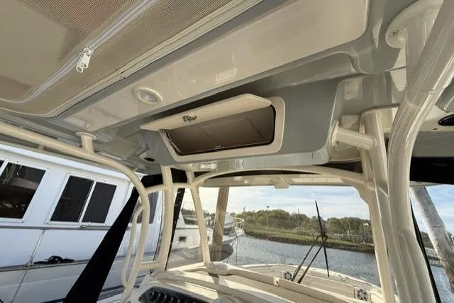 Slide: The Image of 2023 Grady-White Canyon 326 boat interior, showcasing helm and overhead storage. - 35