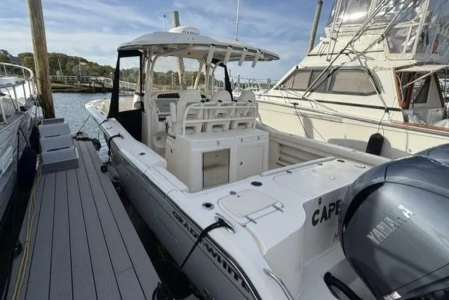 Slide: The Image of 2023 Grady-White Canyon 326 boat docked, featuring spacious seating and Yamaha outboard motor. - 4