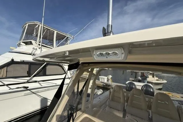 Slide: The Image of 2023 Grady-White Canyon 326 boat docked, showcasing seating and overhead lighting. - 42