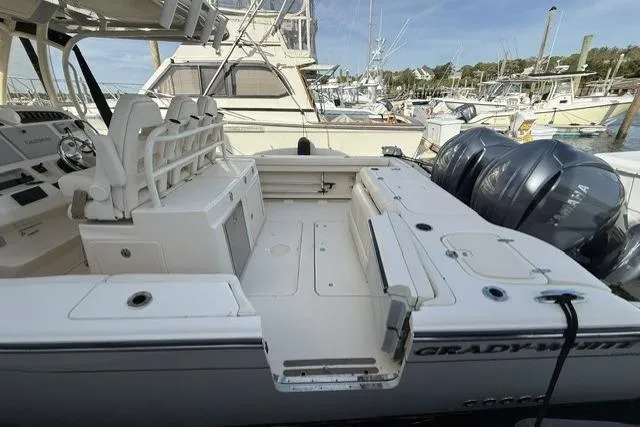 Slide: The Image of 2023 Grady-White Canyon 326 boat docked, featuring spacious deck and dual outboard engines. - 5