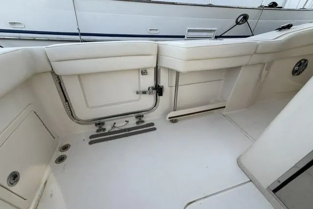 Slide: The Image of 2023 Grady-White Canyon 326 boat interior, featuring white seating and storage compartments. - 50