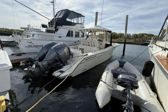 Slide: The Image of 2023 Grady-White Canyon 326 boat docked with twin engines and inflatable dinghy nearby. - 53