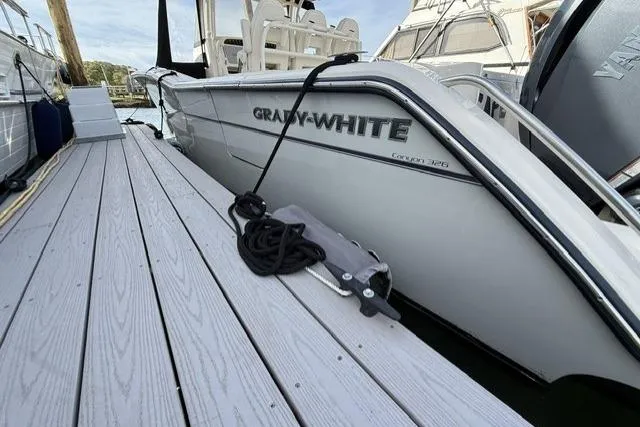 Slide: The Image of 2023 Grady-White Canyon 326 boat docked, showcasing sleek design and branding. - 54