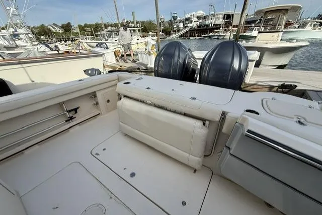 Slide: The Image of 2023 Grady-White Canyon 326 boat interior with dual outboard motors at a marina. - 7
