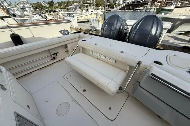 Slide: The Image of 2023 Grady-White Canyon 326 boat interior with seating and twin engines at a marina. - 8