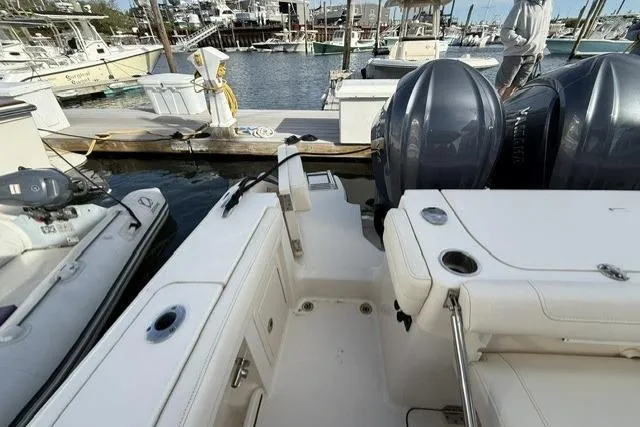 Slide: The Image of 2023 Grady-White Canyon 326 boat docked, featuring dual outboard engines and spacious deck. - 9
