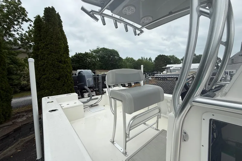 Slide: The Image of 2023 KenCraft 2460 Bayrider boat with seating and outboard motor, parked outdoors. - 6