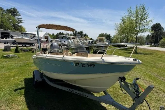 Slide: The Image of 2015 Scout 175 Sport Dorado boat on trailer, parked on grassy area under clear sky. - 1