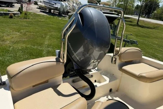 Slide: The Image of 2015 Scout 175 Sport Dorado boat with outboard motor and beige seating, parked on grass. - 7