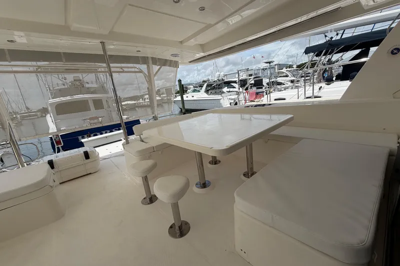 Slide: The Image of Spacious deck area of 2015 Leopard 51 Powercat with seating and table, docked at marina. - 16