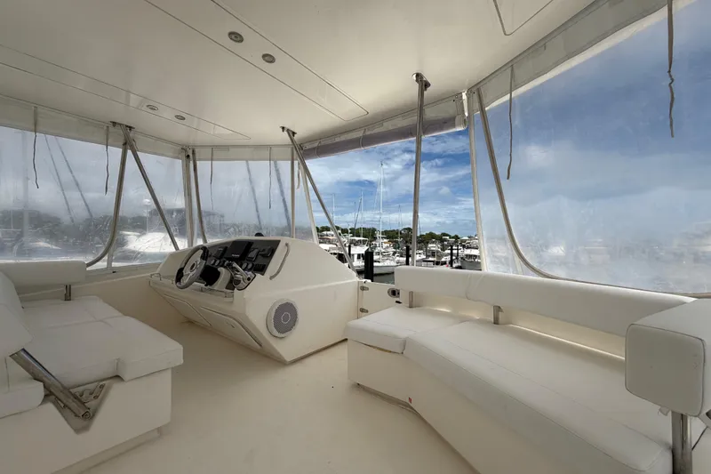 Slide: The Image of 2015 Leopard 51 Powercat interior with helm, white seating, and marina view. - 30