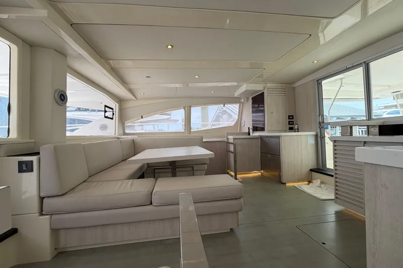 Slide: The Image of Luxurious interior of a 2015 Leopard 51 Powercat yacht, featuring modern seating and kitchen area. - 50