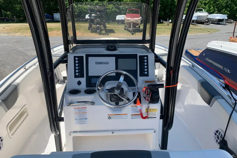 Slide: The Image of 2023 Robalo R222 Center Console boat dashboard with steering wheel and Simrad display. - 3