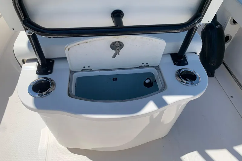 Slide: The Image of 2023 Robalo R222 Center Console boat's livewell and rod holders. - 7