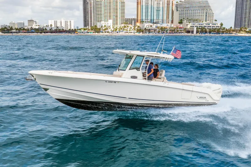 The Image of 2017 Boston Whaler 330 Outrage cruising on ocean near city skyline. - 0