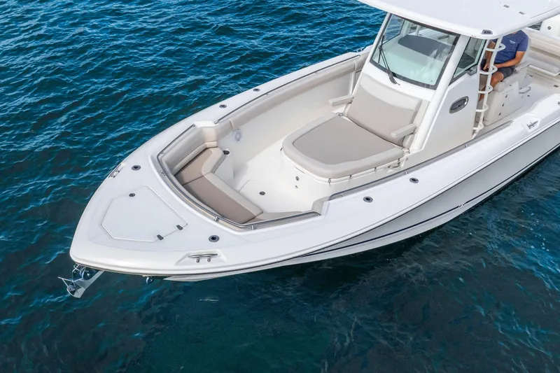 Slide: The Image of 2017 Boston Whaler 330 Outrage boat on clear blue water, showcasing sleek design and spacious seating. - 10