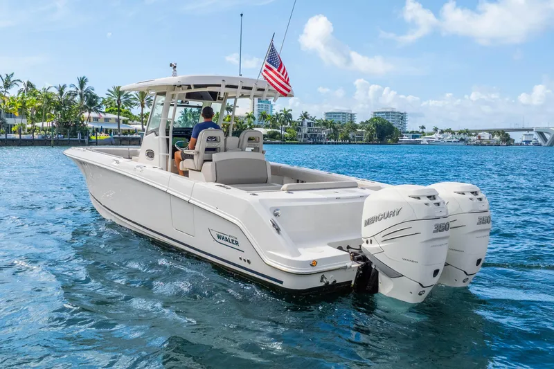 Slide: The Image of 2017 Boston Whaler 330 Outrage boat cruising on blue water with twin Mercury engines. - 11
