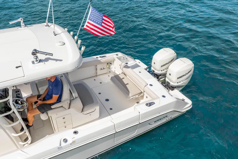 Slide: The Image of 2017 Boston Whaler 330 Outrage boat with dual Mercury engines on clear blue water. - 12