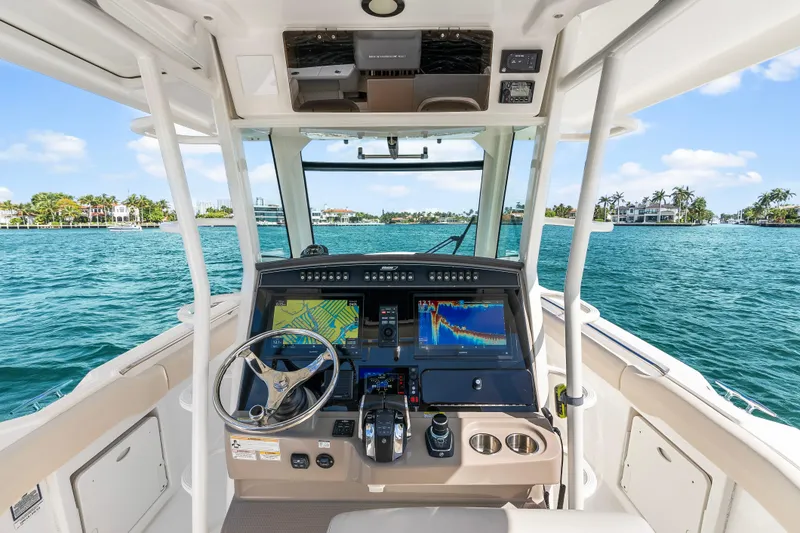 Slide: The Image of Cockpit view of 2017 Boston Whaler 330 Outrage, featuring advanced navigation systems on open water. - 19