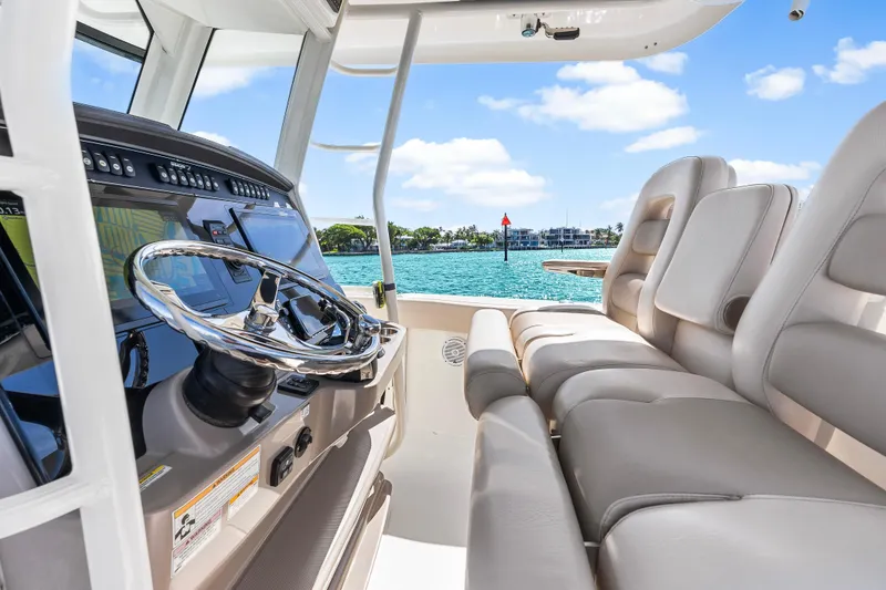 Slide: The Image of 2017 Boston Whaler 330 Outrage helm with luxurious seating and ocean view. - 21