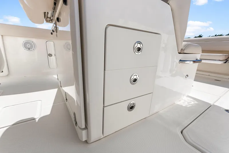 Slide: The Image of 2017 Boston Whaler 330 Outrage interior with storage compartments and seating. - 23