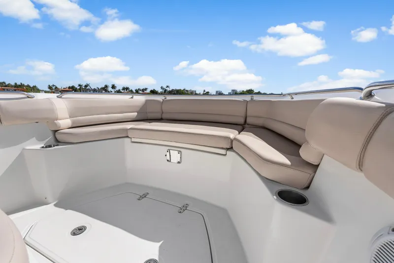 Slide: The Image of 2017 Boston Whaler 330 Outrage boat interior with beige seating under blue sky. - 27