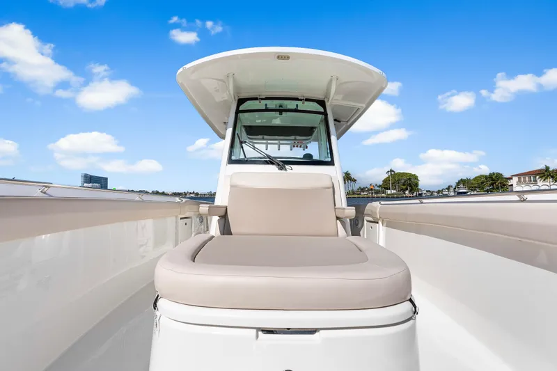 Slide: The Image of 2017 Boston Whaler 330 Outrage boat with cushioned seating, under a clear blue sky. - 28