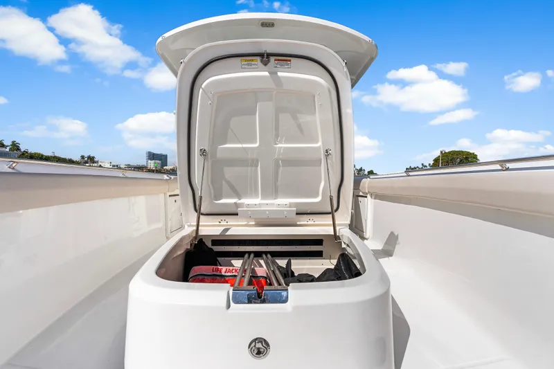 Slide: The Image of Open storage compartment on 2017 Boston Whaler 330 Outrage boat under clear blue sky. - 29