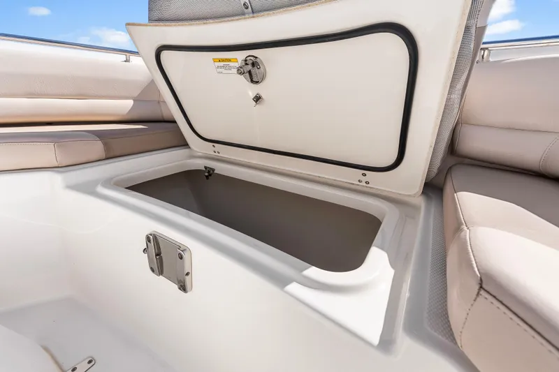 Slide: The Image of 2017 Boston Whaler 330 Outrage storage compartment with open hatch and cushioned seating. - 30