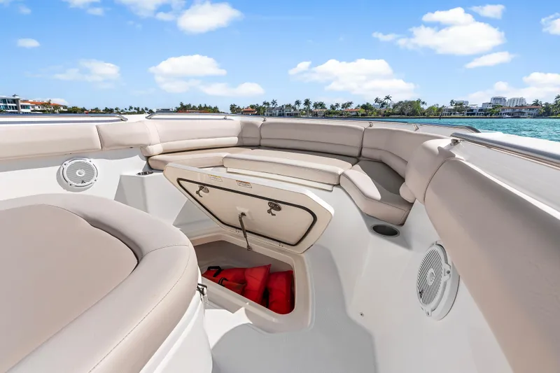 Slide: The Image of 2017 Boston Whaler 330 Outrage boat interior with seating and storage, under a clear blue sky. - 31